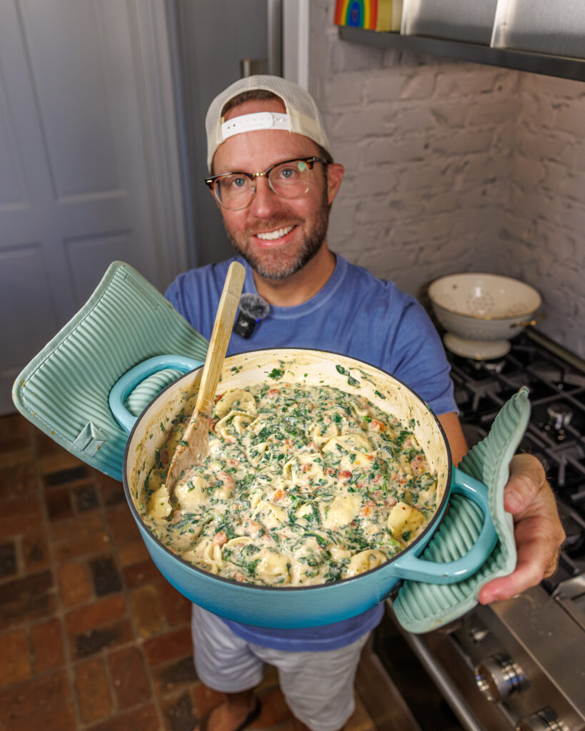 Matthew Bounds, creator of Your Barefoot Neighbor, holds a pot of his creamy and hearty Back to School Too Tired Tortellini