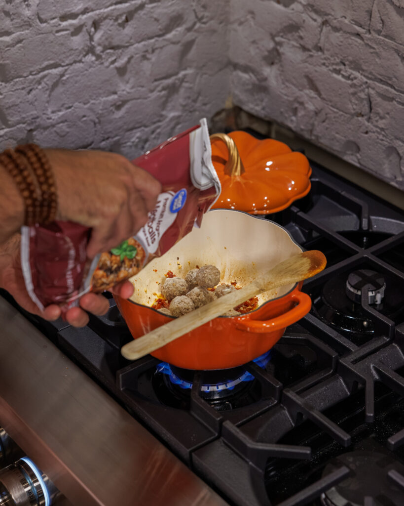 Matthew Bounds, creator of Your Barefoot Neighbor, cooks Goat Cheese Meatball Gnocchi on the stovetop in a pumpkin pot