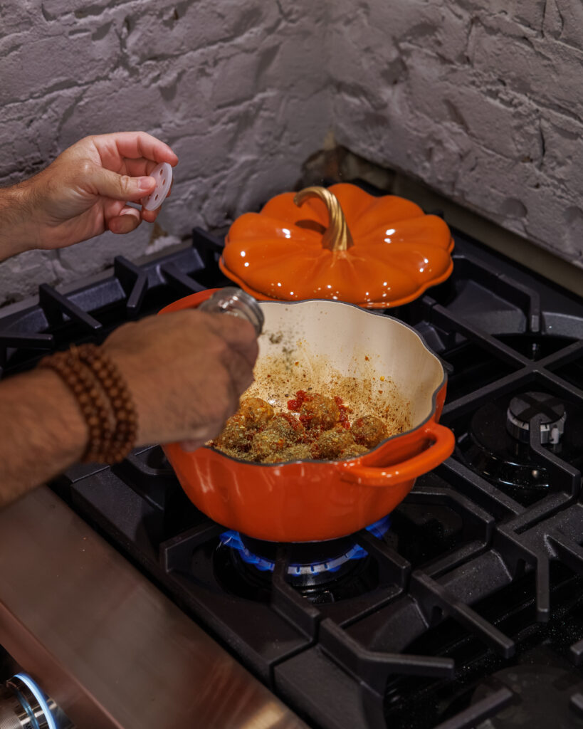 Matthew Bounds, creator of Your Barefoot Neighbor, cooks Goat Cheese Meatball Gnocchi on the stovetop in a pumpkin pot