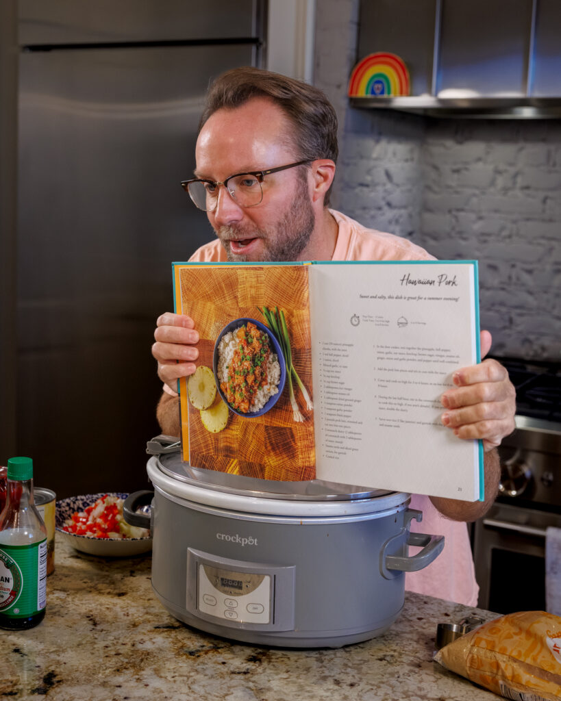 Matthew Bounds, creator of Your Barefoot Neighbor, holds his cookbook Keep it Simple Y'all showing the Hawaiian Pork Crockpot recipe